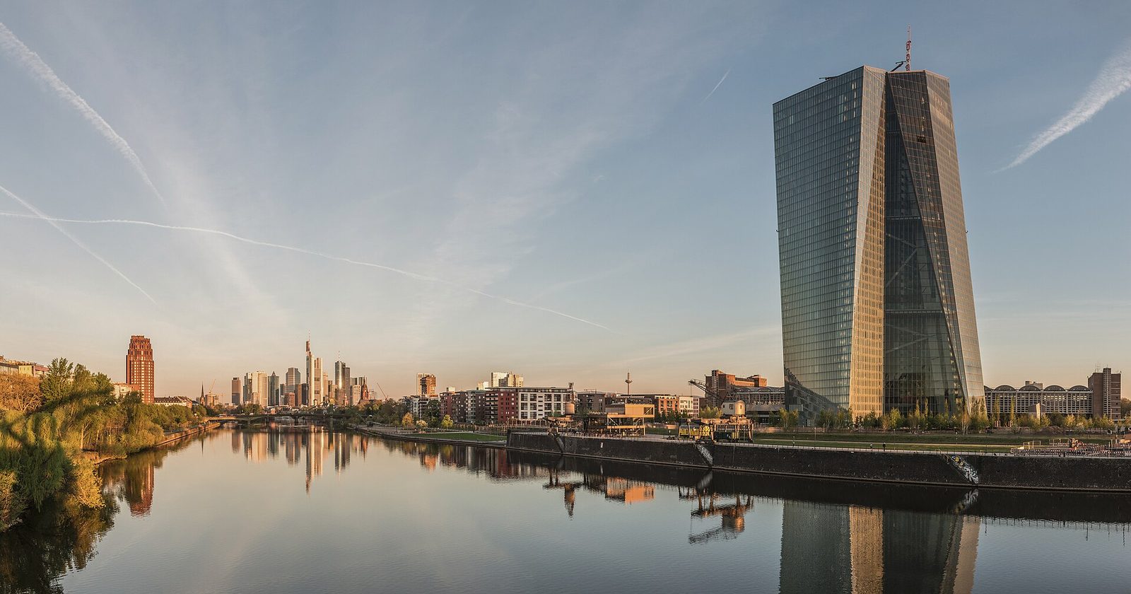 Frankfurt's skyline and the ECB mirrored in the Main at dawn.
